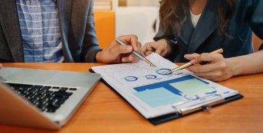 İş dünyası ekibi gelir tabloları ve grafikleri dizüstü bilgisayarla analiz eder. İş analizleri ve stratejik fikirler. Ofiste