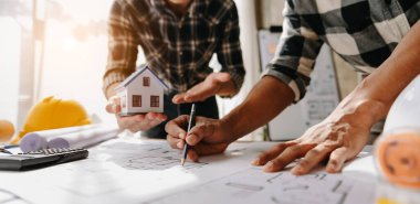 Mühendisler modern ofiste mühendislik ve mühendislik için toplanıyorlar. Mühendisin elleri proje inşaatı üzerinde çalışıyor.