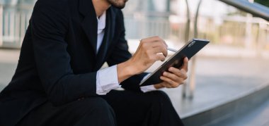 man and tablet pc while sitting in blurred office background
