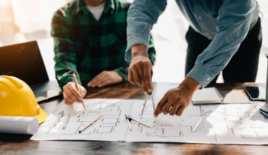 Engineer teams meeting working together wear worker helmets hardhat on construction site in modern city. industry professional team on office