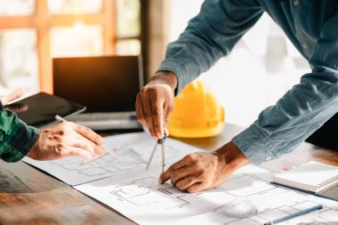 Yaratıcı mimar karanlık çatı ofiste büyük çizimler veya gün ışığına kafede projelendirme