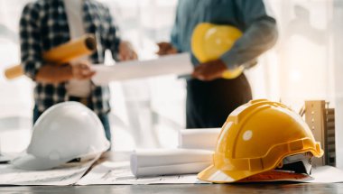 Engineer desk with object paper with blurry engineer teamwork hardworking to consults about their building project. in office