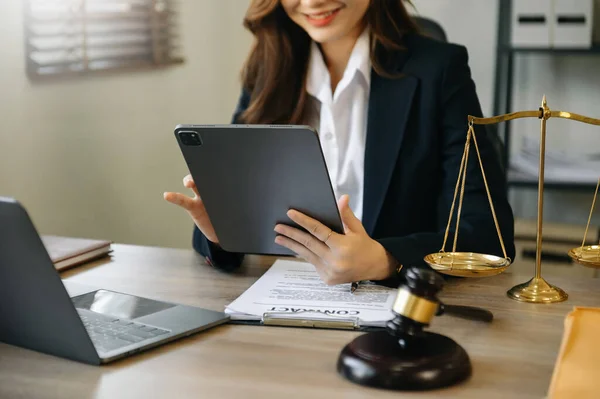 justice and law concept. asian woman lawyer working and judge in a courtroom the gavel, working with tablet and laptop