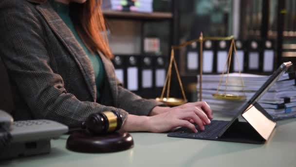 司法と法律の概念法廷で女性裁判官は砂場で朝の光の中で木製のテーブルの上でデジタルタブレットコンピュータと協力して — ストック動画