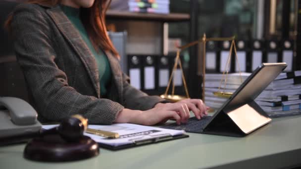 司法と法律の概念法廷で女性裁判官は砂場で朝の光の中で木製のテーブルの上でデジタルタブレットコンピュータと協力して — ストック動画