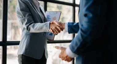 Two confident businesspeople shaking hands during a meeting in the office, success, dealing, greeting and partner in sunlight