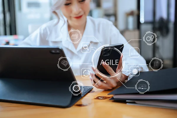 Agile development methodology concept. Businesswoman using l tablet with virtual screen Agile icon on office digital technology concept