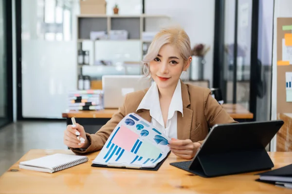 Woman freelancer is working her job on computer tablet , Doing accounting analysis report real estate investment data, Financial at modern office