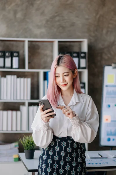 Confident business expert attractive, smiling, young woman holding phone in creative office.