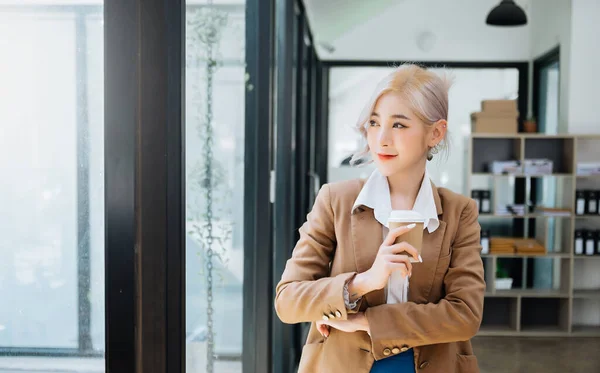 Confident business expert attractive,young woman holding coffee in office