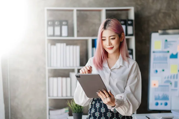 Confident business expert attractive ,young woman holding digital tablet   in creative office.