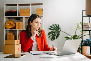 Small business entrepreneur SME ,freelance woman working at home office, BOXes,tablet and laptop online, marketing, packaging, delivery,  e-commerce concept in home office