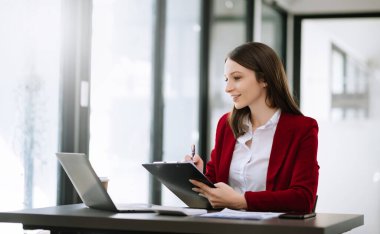 Young beautiful woman and laptop while sitting at the working wooden table office
