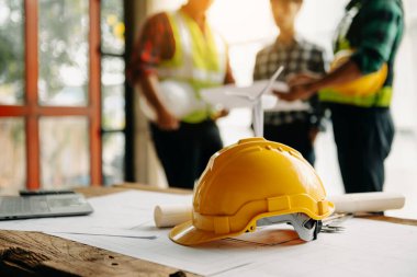 Engineer teams meeting working together wear worker helmets hardhat on construction site in modern city.Asian industry professional team in sunlight