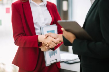 Modern ofisindeki bir toplantı sırasında el sıkışan iş adamları