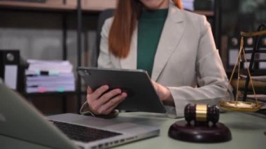 justice and law concept.female judge in a courtroom  the gavel, working with  laptop and digital tablet computer on table