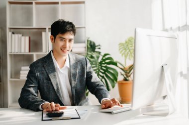 Young Asian businessman working at office with computer