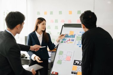The boss stands near the board with graphs, demonstrates statistics, various personnel attending the training, introduces the new products of the company, in modern office