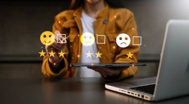 Customer service evaluation concept. Businesswoman pressing face smile emoticon show on virtual screen at tablet  in office