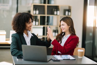 İş kadınları çalışır ve iş planlarını tartışırlar. Bir insan çalışanı, meslektaşına ofisteki sonuçları açıklar ve gösterir.
