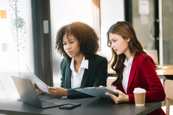 stock image Two  businesswomen working together with laptop  in modern office with coffee