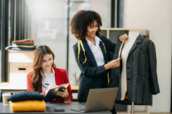 Diverse female fashion designers at work with tailor centimeters on neck . independent creative design business.