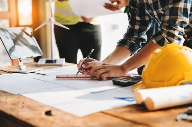 Meslektaşlar, işyerindeki inşaat sahasında mimari proje hakkında veri çalışması ve tableti tartışıyor