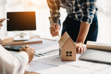  Meslektaşları çalışma ve tablet verilerini, bilgisayarlarını ve mimari projelerini ofisteki inşaat sahasında tartışıyorlar.