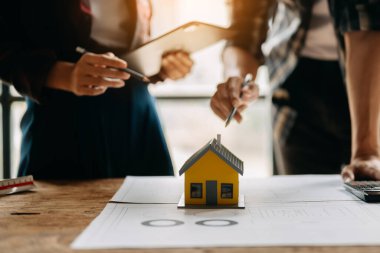 Modern ofisteki inşaat alanında mimari projeyle veri çalışması ve tableti tartışan iki meslektaş