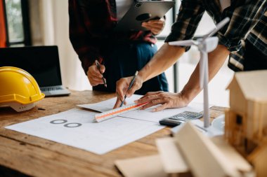 Mühendisler toplantı yapıyor. İnşaat alanında birlikte çalışıyorlar.