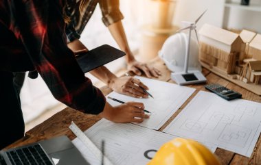 Mühendis ekipleri modern şehirdeki inşaat sahasında birlikte çalışıyorlar. Sektörde profesyonel takım