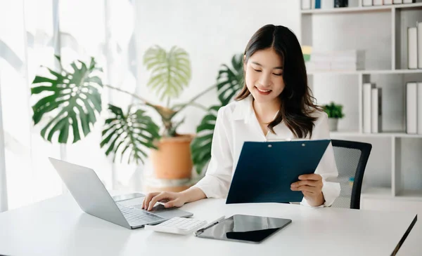 Confident businesswoman with  tablet pc and laptop in home office