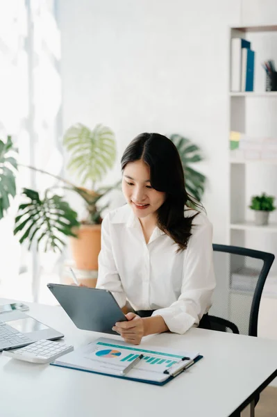Confident businesswoman with  tablet pc and laptop in home office