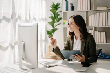 Yaratıcı ofiste bilgisayarı olan kendine güvenen bir iş kadını..