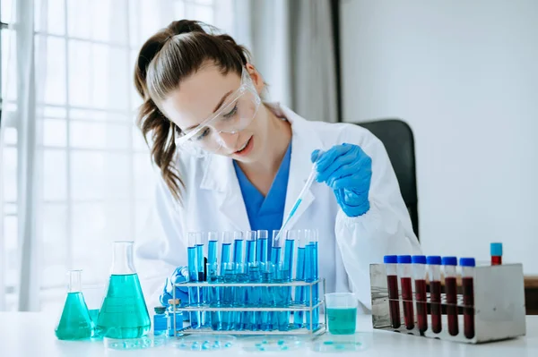 stock image Female scientist researcher conducting an experiment in the chemical laboratory