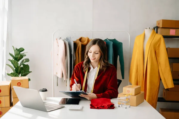 stock image Fashion blogger concept, Young woman selling clothes on video streaming.Startup small business SME, using smartphone or tablet taking receive and checking at home office