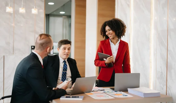 stock image Happy businesspeople  on a new project in an office. Group of diverse businesspeople using a laptop  in modern office