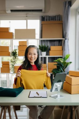 Moda blogcusu kavramı, üst düzey Asyalı kadın video yayınında kıyafet satıyor. Küçük işletme KOBİ 'si başlat, tablet alımı ve denetimi merkez ofiste kullan