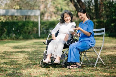 Kıdemli kadın arka planda bir doktor tarafından muayene ediliyor. Hastane bahçesi konsepti. 