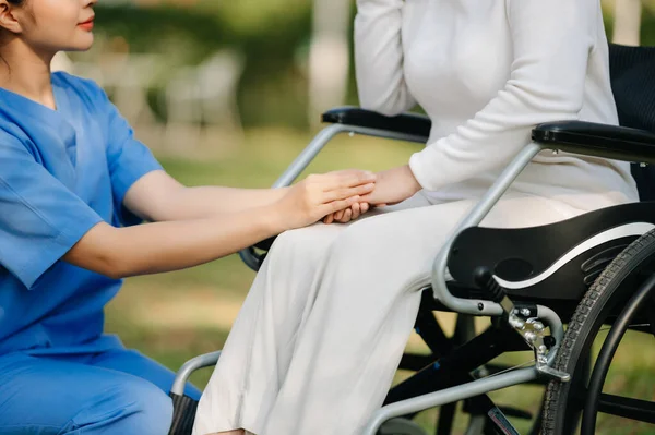 亚洲老年老年妇女坐在轮椅上 由亚洲小心照顾者照料 疗养院花园概念 — 图库照片