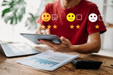 Müşteri hizmetleri değerlendirme konsepti. İş adamı tabletteki sanal ekranda gülümseme gösterisine basıyor 