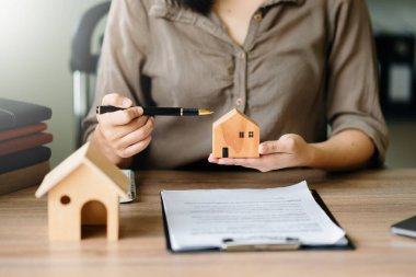 Considering buying a home, investing in real estate. Broker signs a sales agreement. agent, lease agreement, successful deal in office