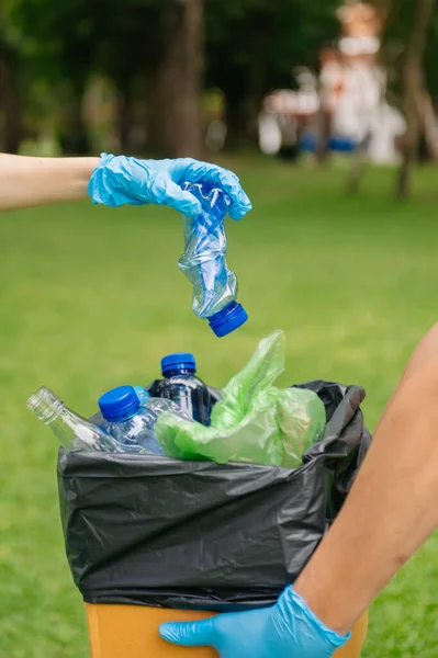 stock image  hands holding garbage  putting into recycle bag .Clearing, pollution, ecology and plastic concept