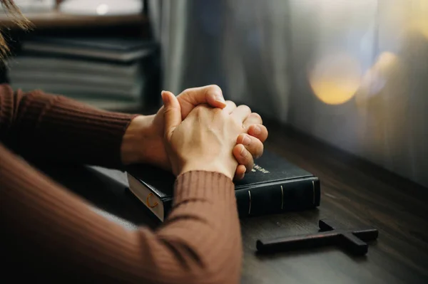 stock image Hands together in prayer to God along with the bible In the Christian concept and religion, woman pray and Bible on the wooden table