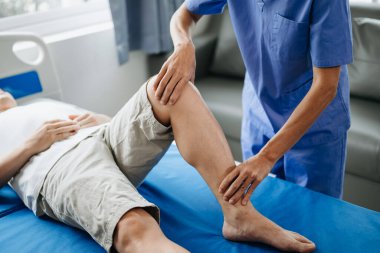 Klinikteki yatakta hastayla birlikte çalışan fizyoterapistin kapağını kapat.