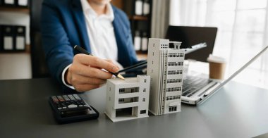 Considering buying a home, investing in real estate. Broker signs a sales agreement. agent, lease agreement, successful deal  in office