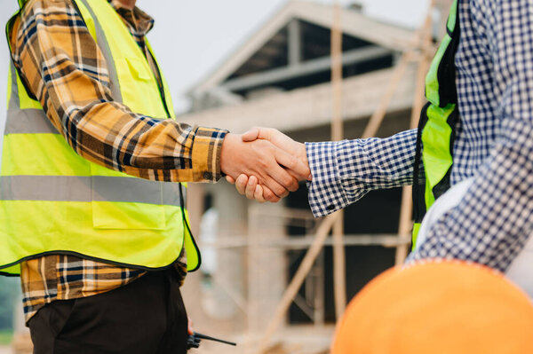 Engineer and contractor join hands after signing contract,They are having a modern building project together. successful cooperation concept