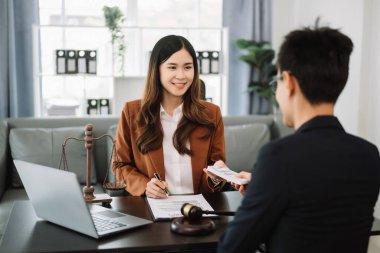 Adalet ve hukuk kavramı. Avukatlık bürosundaki zarfın içinde rüşvet parası var. İş kadını erkekten rüşvet alıyor.