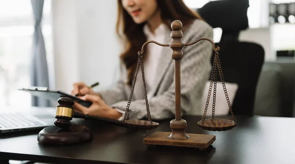 Adalet ve hukuk kavramı. Mahkeme salonunda masa başında bilgisayarla çalışan bir kadın yargıç.