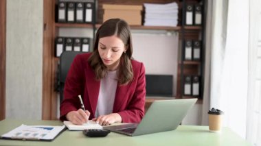 Bilgisayarlı genç ve güzel bir kadın modern ofiste çalışıyor.